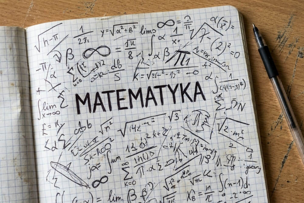 Pierwsza strona zeszytu z dużym napisem „Matematyka” i chaotycznie rozsypanymi symbolami matematycznymi wokół